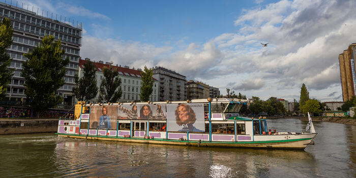 Flussboot mit C&A-Werbebannern am Donaukanal
